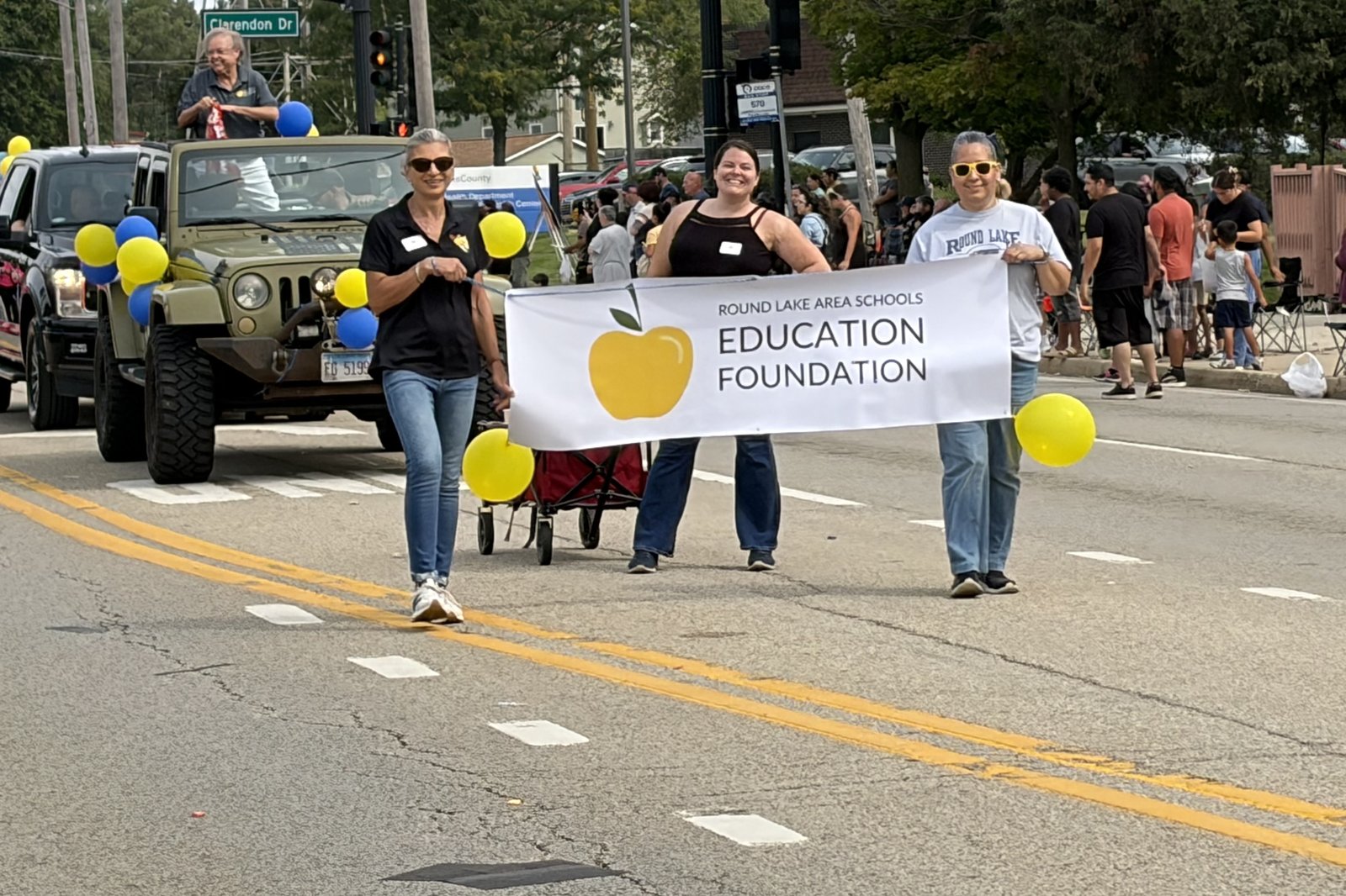 Volunteers carrying the Education Foundation banner along the parade route